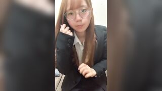 Một nữ nhân viên văn phòng người Nhật đeo kính đang chụp ảnh tự sướng.