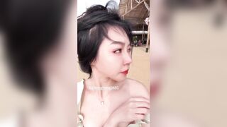 Dâm nữ xinh đẹp vừa đi dạo trên bãi biển vừa vạch áo show cặp vú nhỏ nhắn của mình