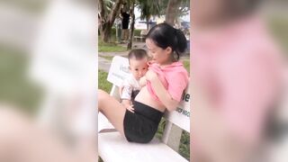 Chị gái cho con bú giữa công viên